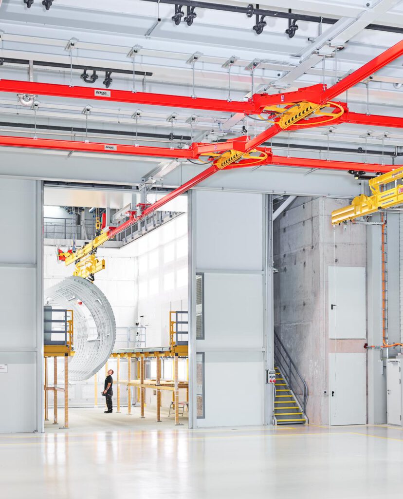 Industriefotografie aud dem Flugzeugbau: Ein Seitenteil wird transportiert mit einem Kran.